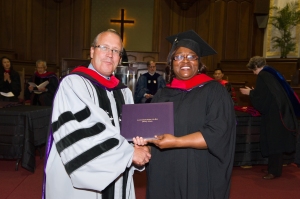 Chairman of the ABSW Board of Trustees Rev. Dr. Jim Hopkins presents M.Div. graduate Loretta Dickerson-Smith with her diploma.